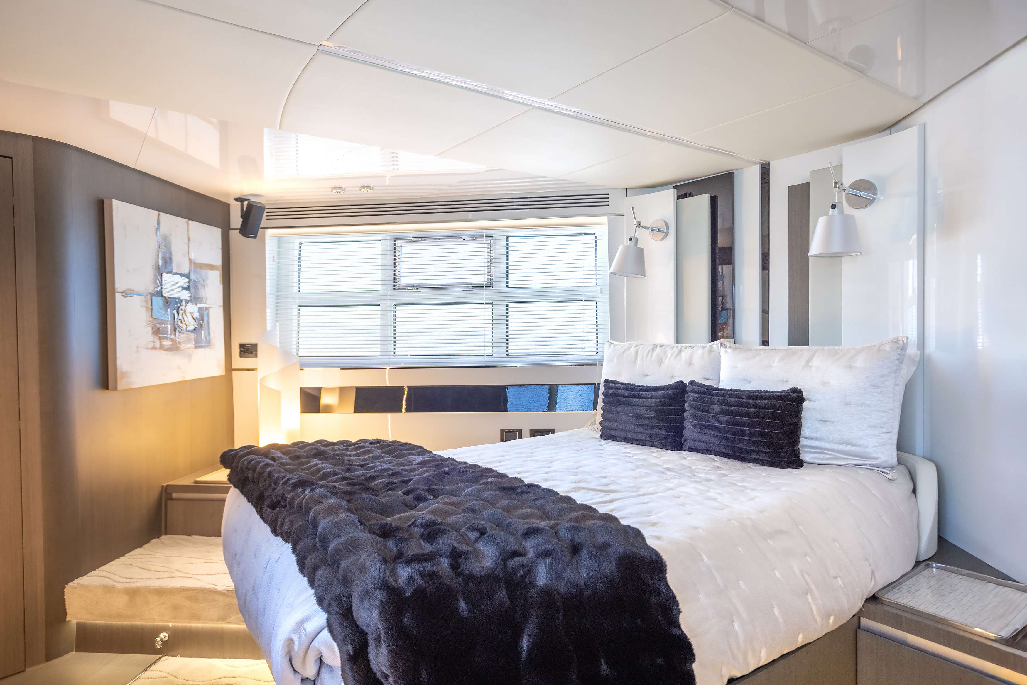 Master suite with abstract art, window blinds and plush fur throw